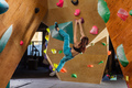 Young woman climbing on overhanging wall in bouldering gym - PhotoDune Item for Sale