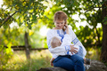 Mother breastfeeding baby son outdoors. Woman and her son wearing Ukrainian style shirts. - PhotoDune Item for Sale