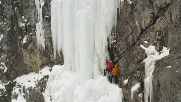 Astonishing view of two climbers on frozen ledge climbing Maineline, Mount Kineo