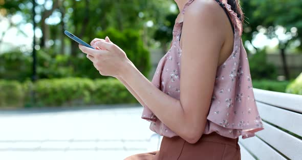 Woman Use of Mobile Phone Online in The Park