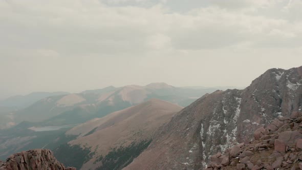 Thick wildfire smoke covers peaks of Colorado mountain range. Aerial parallax.