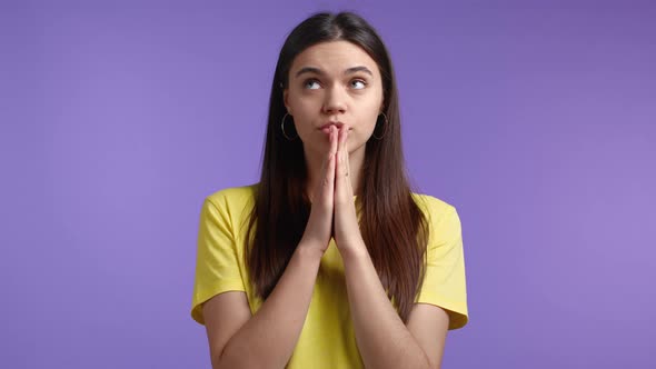 Pretty Woman in Yellow Tshirt Praying Over Violet Background