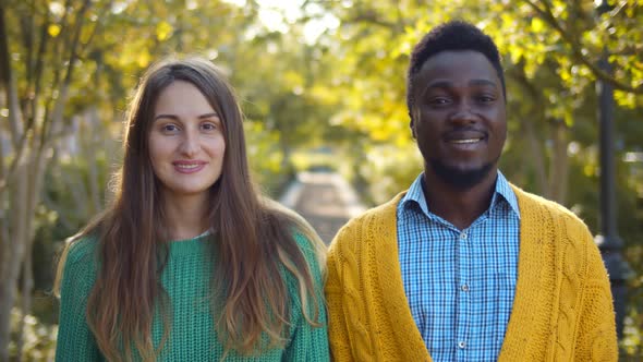 Portrait of Romantic and Mixed Race Young Couple Standing in Park