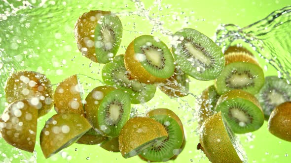 Super Slow Motion Shot of Flying Fresh Kiwi Slices and Water Side Splash at 1000 Fps alt