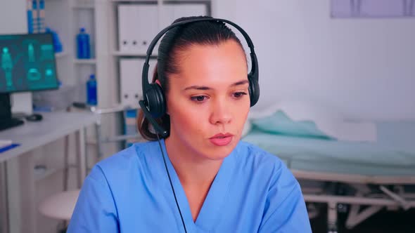 Specialist Nurse Answering Using Headphones Checking Appointment During Telehealth