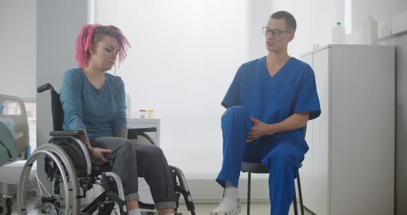 Physiotherapist Doctor Helping Woman in Wheelchair Doing Rehabilitation Exercises