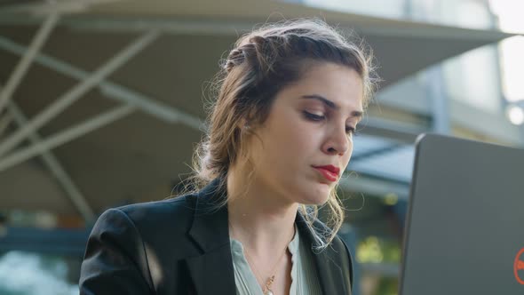 Young business woman sitting in a cafe working on a laptop computer