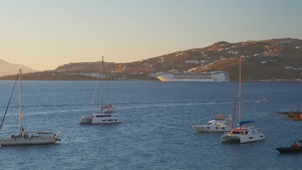 Sunset in Mykonos, Greece, with Cruise Ships and Yachts in the Harbor