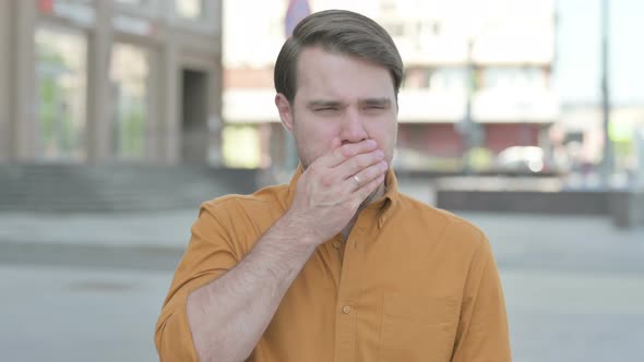 Young Man Coughing while Standing Outdoor