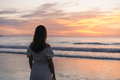 Lonely young asian woman standing on the beach at sunset - PhotoDune Item for Sale