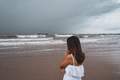 Young woman feeling lonely and sad looking at the sea on a gloomy day - PhotoDune Item for Sale