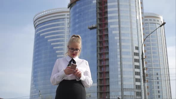 business woman with a phone on the background of skyscrapers