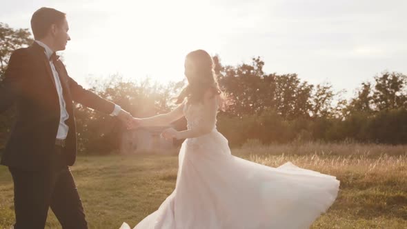 Happy Widding Couple Dancing on Nature on Sun Blinks