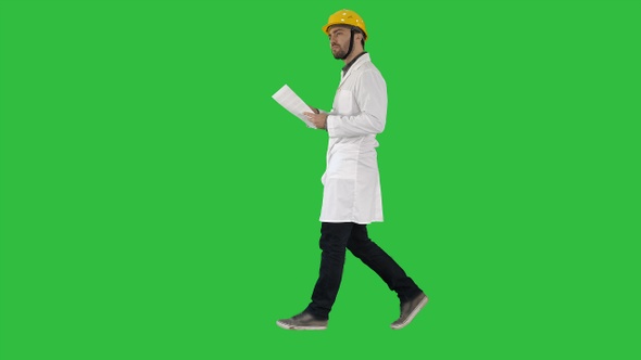 Engineer manager walking with hard hat is holding paper