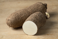 Whole and halved raw African yam on wooden background - PhotoDune Item for Sale