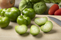 Fresh green whole and halved tomatillo on a cutting board - PhotoDune Item for Sale