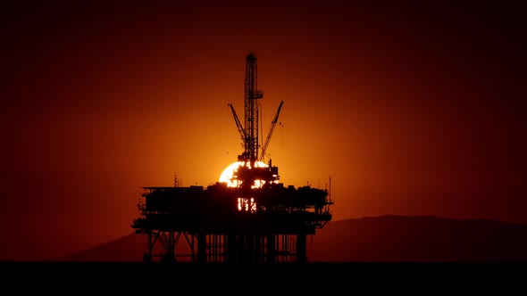 Time lapse of the sunset behind an offshore oil platform