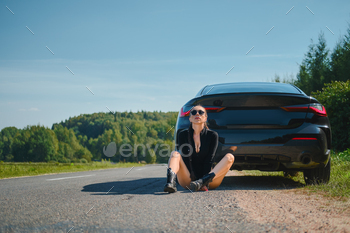 sits on asphalt by her powerful racing car