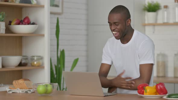 Sporty African Man Doing Video Call on Laptop in Kitchen