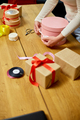 Hands of unrecognisable woman wrapping with ribbon a pink present - PhotoDune Item for Sale