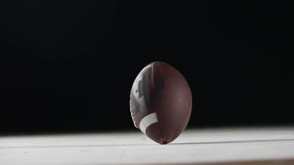 American Football Rotates Against Black Background Close Up