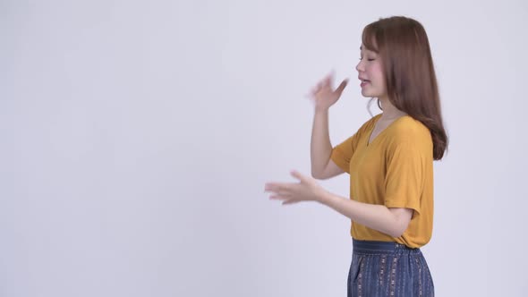 Profile View of Young Angry Asian Woman Talking and Gesturing