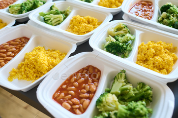 Part of table served with steamed broccoli, kasha and boiled beans in containers