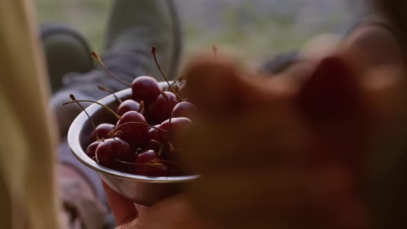 Unrecognizable Travelers Eating Cherry