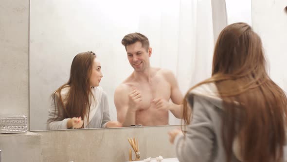 Beautiful Couple Dances and Sings in Front of Bathroom.