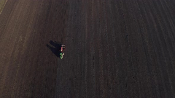 Aerial View Of Harvest Fields. Tractor Driving Across The Field.