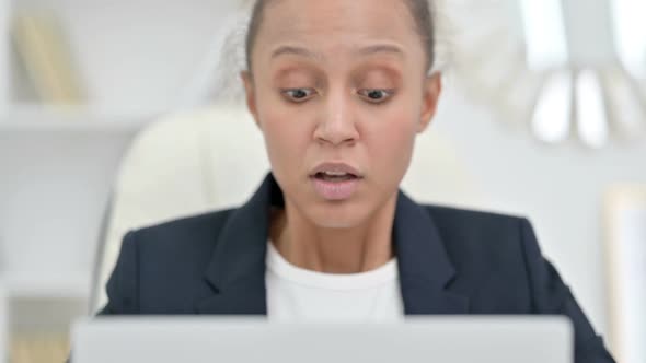 African Businesswoman Reacting to Loss on Laptop