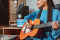 Stylish dreadlocks musician plays guitar and records new song in recording studio - PhotoDune Item for Sale