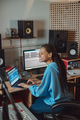 Woman sound engineer, composer works on laptop in radio presenter office of audio recording studio - PhotoDune Item for Sale