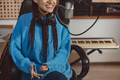 Beautiful toothy smile talking into microphone in the broadcasting and music recording studio - PhotoDune Item for Sale