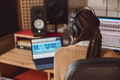 Musician with headphones sitting at desk with laptop while recording new song in the music studio - PhotoDune Item for Sale