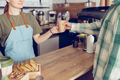 Female barista giving cup of coffee to customer in cafe - PhotoDune Item for Sale