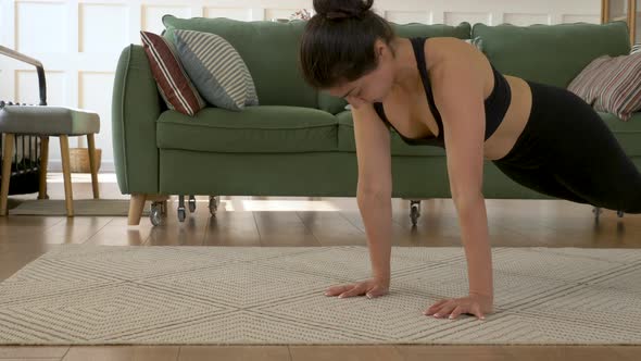 A young Indian woman is Working out at home, doing push-UPS, a Bright Cozy Room