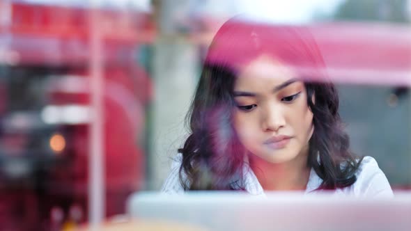 Pensive Casual Asian Businesswoman Enthusiastically Working Looking at Screen Using Laptop