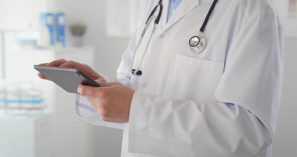 Cropped Shot of Man Doctor Checking Data on Digital Tablet