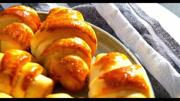 Homemade Delicious Croissants on a Dessert Gray Plate on Kitchen Towel Rotating