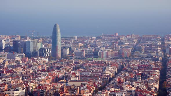 Panning shot high angle of Barcelona city on sunny day overlooking the sea