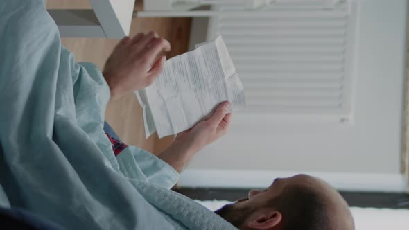 Vertical Video Adult with Migraine Reading Paper with Information