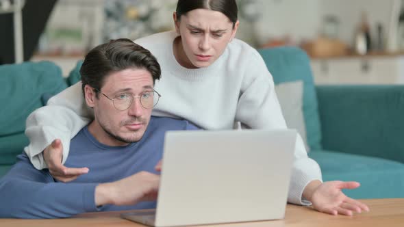 Hispanic Couple Having Loss While Using Laptop Together