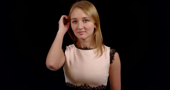 Charming and Modest Slavic Woman Is Posing for Camera in Black Background, Touching Chin By Hand