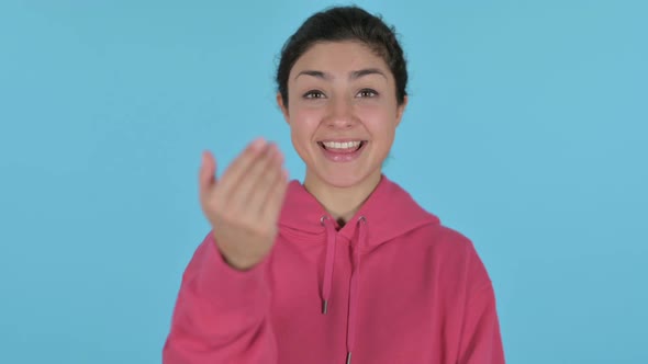 Indian Girl Pointing at the Camera and Inviting  Blue Background