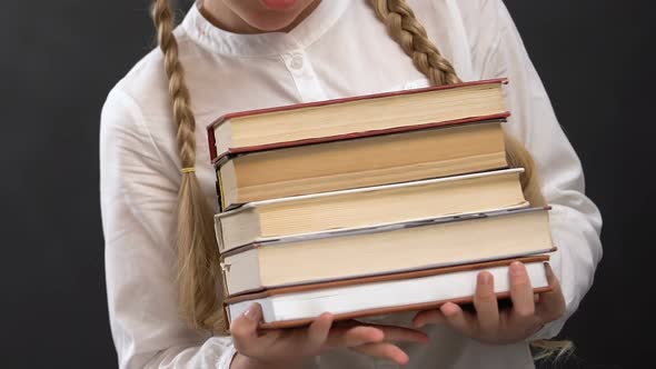 Schoolgirl in Eyeglasses Holding Books Against Blackboard, Education, Geek