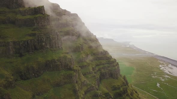 An aerial footage of a mountain with puffins flying