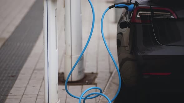 Electric Tesla Car Charging at Power Station