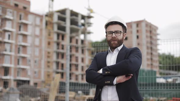 Portrait of Architect Man in Business Suit Standing on the Construction Site with Crossed Hands