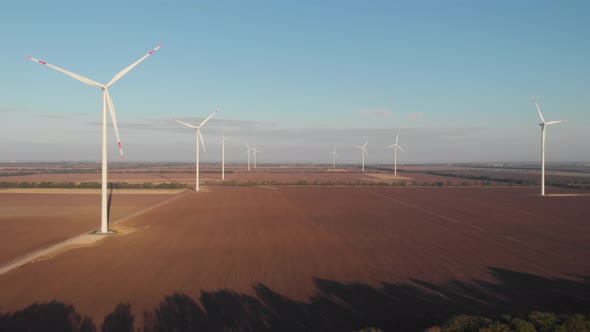 Wind turbines power plant farm aerial sunset view clear sky green energy